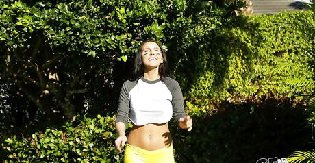 Enchanting brunette babe Alicia Tease in fancy shorts exhibits big tits and sexy butt outdoor