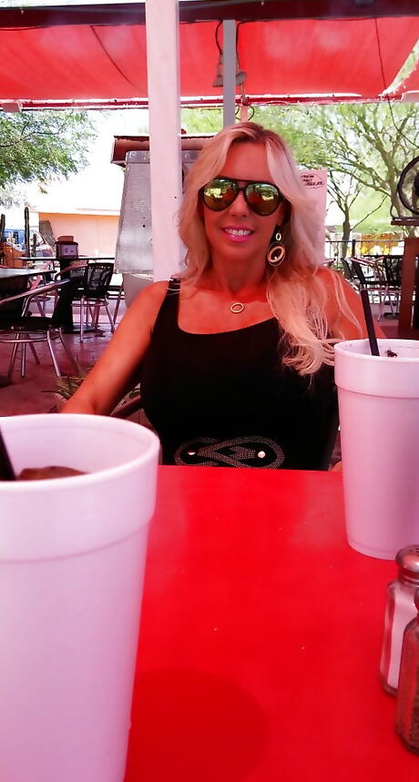 Very attractive american housewife Sandra Otterson posing in sexy glasses on camera outdoor