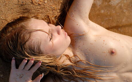 Slender blonde youthful Sunny A exhibiting her butt at beach