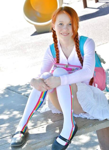 Luscious american red-haired teen Dolly Little in fancy skirt exposing small tits and playing with dildo outside