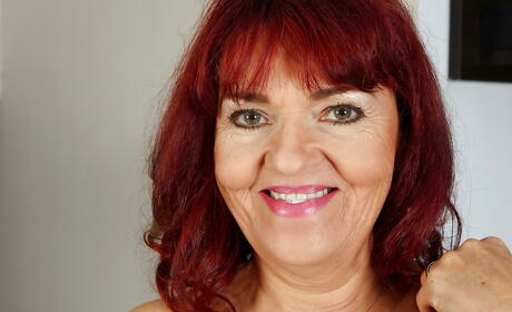 Superb redheaded mature Natalia baring big knockers and bald pussy 