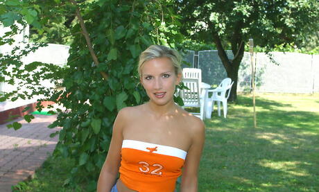 Luscious blonde young Camilla shows big hooters and hot ass outside