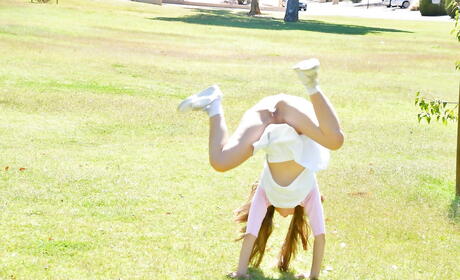 Sexy youthful Kelly Kitten in skirt revealing small tits and toying her cunt outside