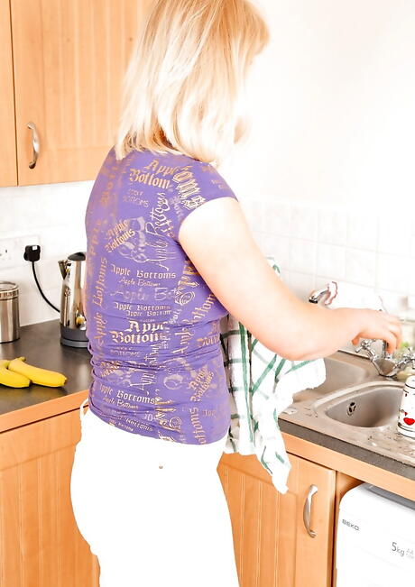 Sultry blonde mature Suzy Wilde showing big titties and masturbating with dildo in kitchen