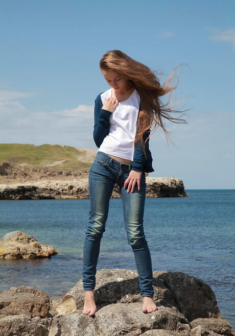 Gracile blonde teen Milena D in jeans exhibits small tits and butt on the beach