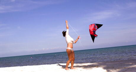 Seductive german dark-haired milf Chloe Vevrier in beautiful bikini shows big tits and spreads her legs on the beach