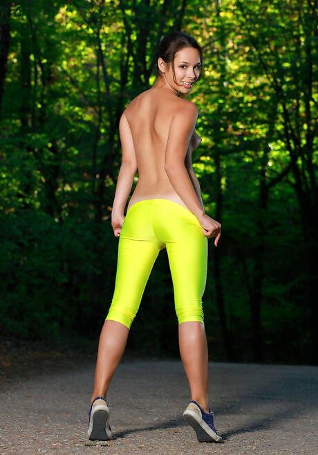 シルフのようなブルネットのティーン、エミーがお尻と禿げたアソコを外で見せている。
