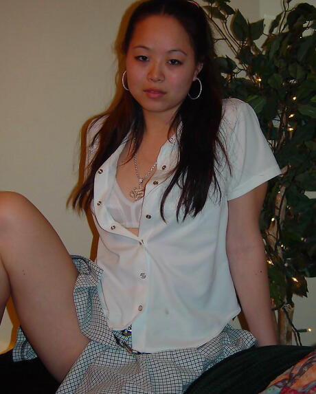 Formell asiatisches dunkles Haar Jugendliches China im ausgefallenen Rock enthüllt ihren Hintern und verbreitet ihre Beine
