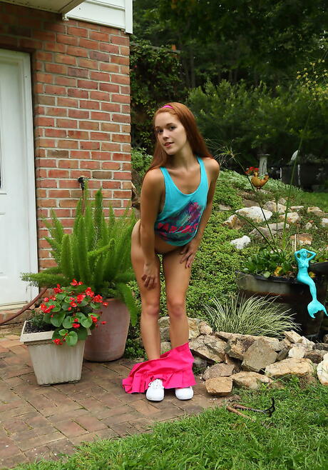 Hot redhead teen Kymberly Brix in sexy skirt exhibits tiny tits and toys her cunt outdoor