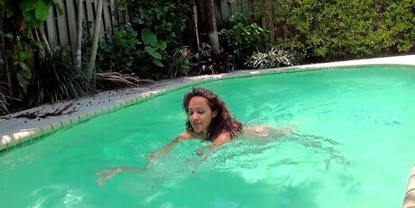 Mycket attraktiv mörkhårig brud Michell Devine Bares Tiny Tit och sexig rumpa nära poolen
