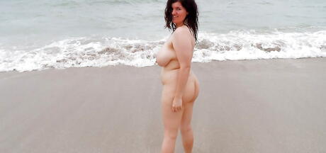 Incantevole ragazza Dulcinea in pantaloncini sexy che mostra grandi knocker e culo sulla spiaggia
