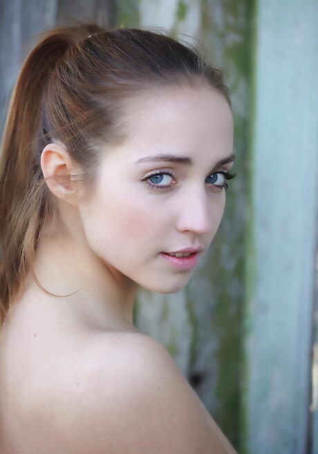 Gracile unge Milana G i smarte nederdel udviser små bryster og spreder hendes ben
