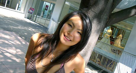 Attractive japanese hottie Asami in shorts posing outside