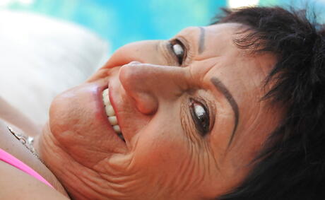 Herlig Grannie Anastasia i varmt undertøy avslører store pupper og barberte fitte ved bassenget
