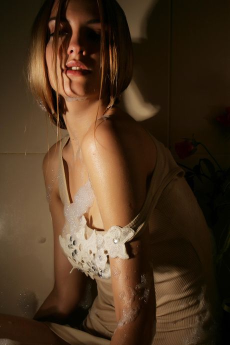 Skinny blonde Kira W gets naked in a bathtub while smoking a cigarette