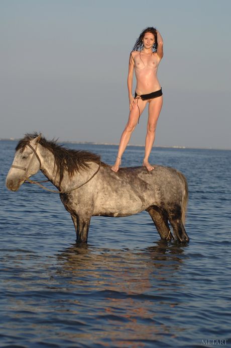 Slender teen Olga K shows her tiny tits and poses naked on the beach