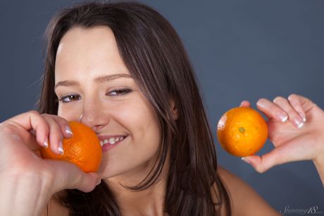 Bashful teen Edison X holds a clementine while posing naked in a solo shoot