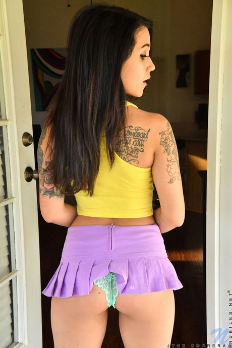 Cute teen Jynx Correra shows her tiny tits and her shaved pussy in a solo