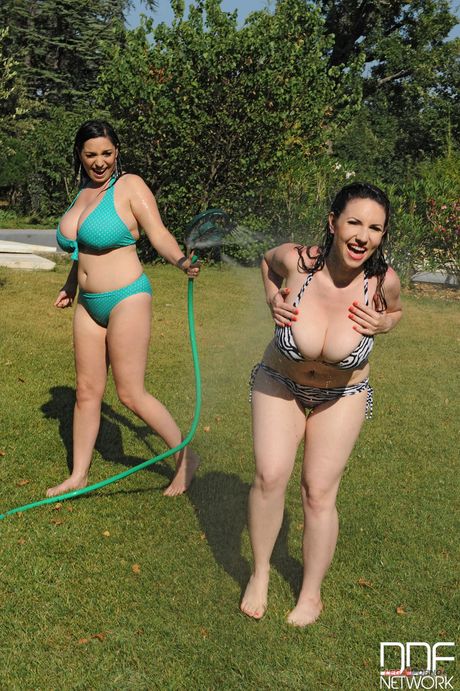 Hete lesbiennes Karina Heart en Michelle Monaghan spelen met een slang in de tuin
