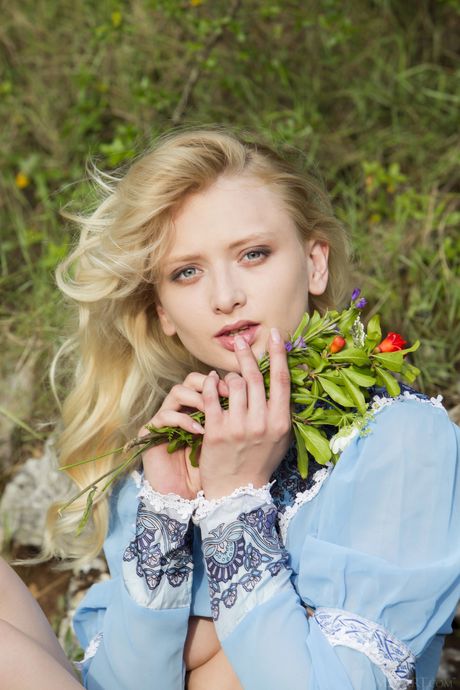 Blonde girl Nika N removes a long dress to pose nude in a field of flowers