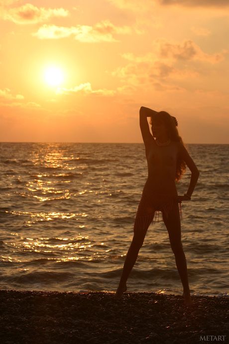 Ukrainian erotic model Nastya A poses nude on a rocky beach & displays her small tits