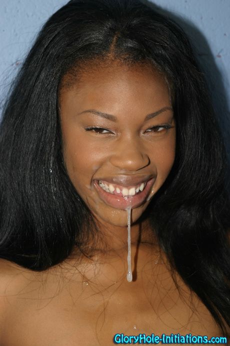 O adolescente preto Andrina suga um pau branco através de um buraco de glória em um banheiro
