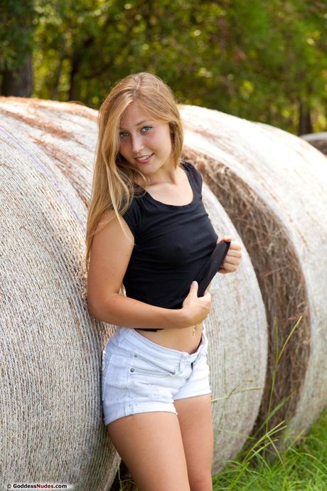 Young brunette Breen gets naked in a field of hay by herself