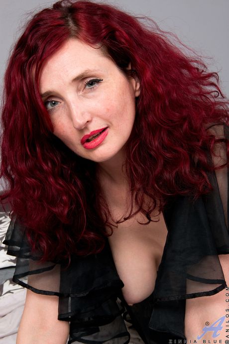 Redheaded mature Zinnia Blue shows her big tits and masturbates