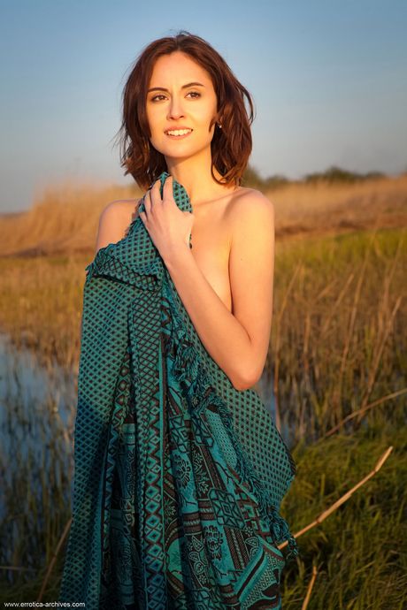 يطرح Svelte Teen Sade Mare عارية في حقل من العشب الطويل
