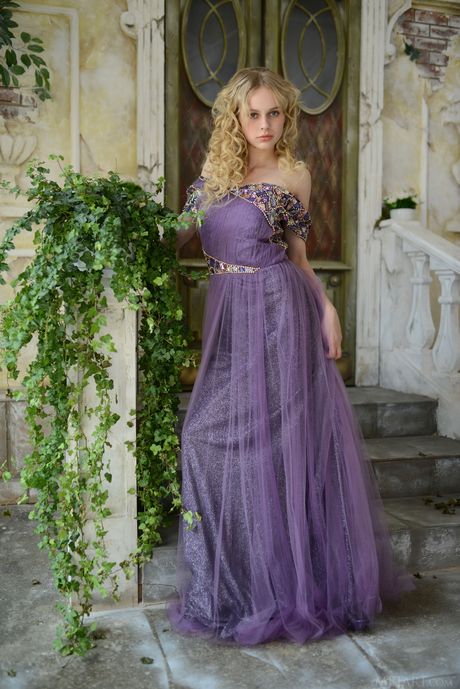 Blonde teen Angelika D models naked on a staircase in a backyard