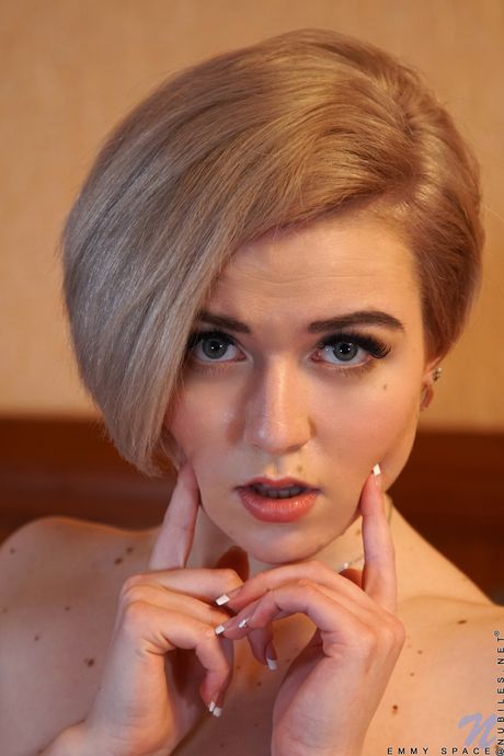 Blonde beauty Emmy Space fingers her pussy after getting naked