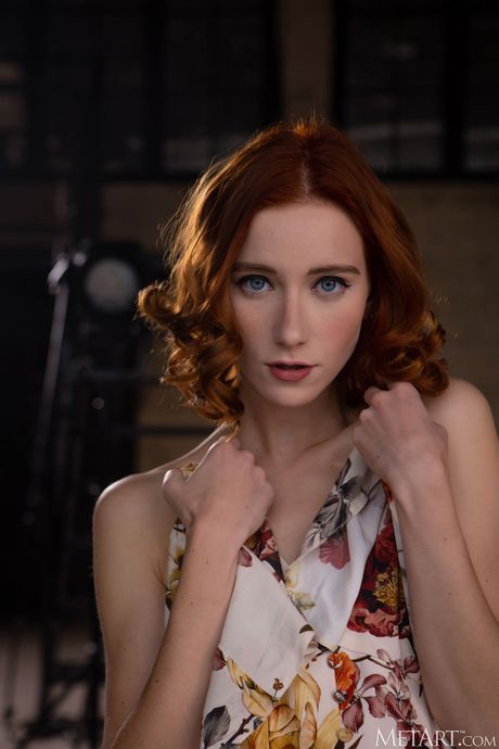 Den ryska rödhåriga Rona Talin randar sig på en soffa under en solo -shoot
