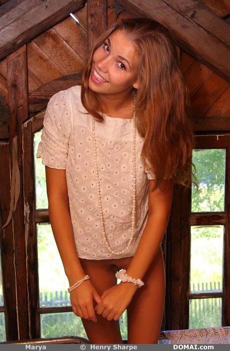 Solo girl with long red hair and nice tits strips down on a bed