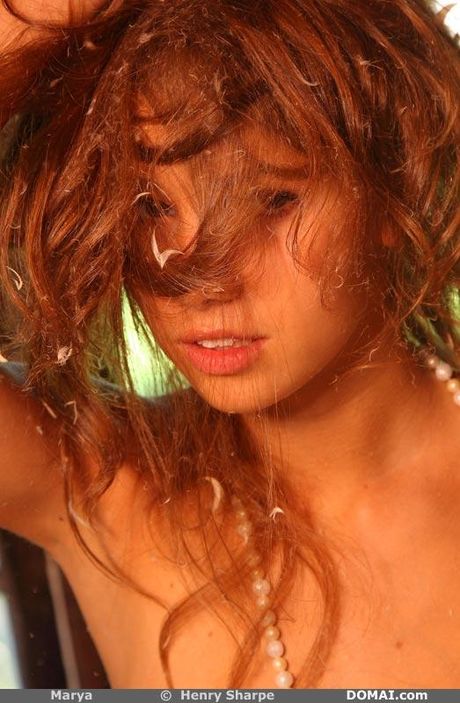 Solo girl with long red hair and nice tits strips down on a bed