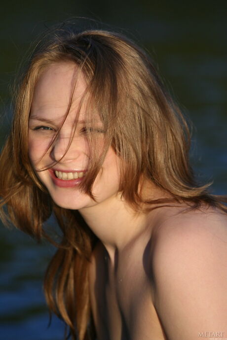 Blonde teen Mia C takes off everything on a rocky beach