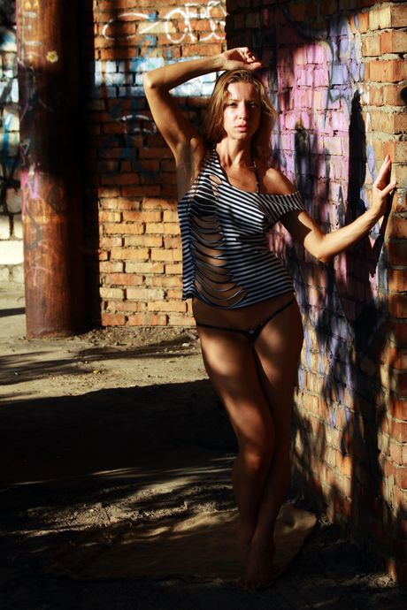 Blonde teen Mika A strikes great nude poses on a balcony in the sun