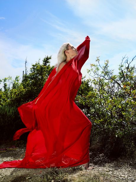 Young blonde Adele B models totally naked on a rocky outcropping