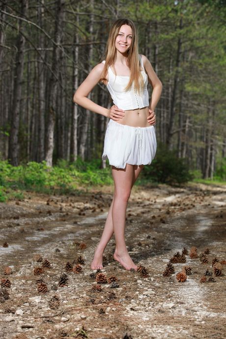 Slender teen Violet bares it all in a forest while alone