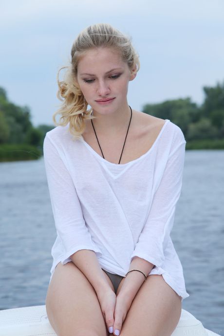 Gorgeous teen Monique C poses totally naked on a boat in the river