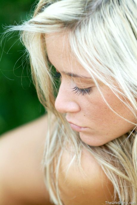 Sexy blonde Jana H poses naked in high heels on a rocky cliff