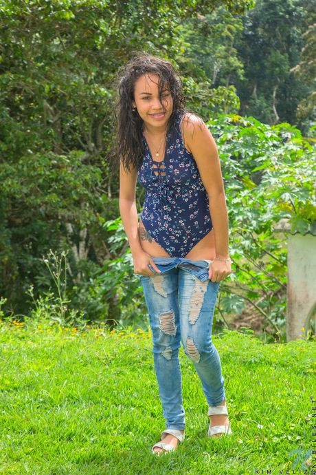 Endearing teen Kim Veliz shows her tiny tits and fingers her pussy outdoors