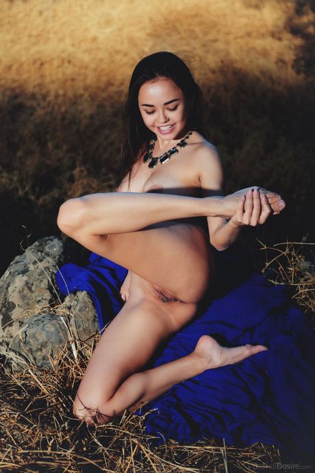 Sweet Asian teen Li Moon models totally naked on a cliff in the countryside