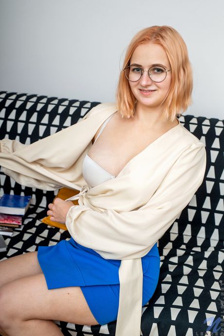 Redheaded teen Leane removes her glasses before showing her big tits