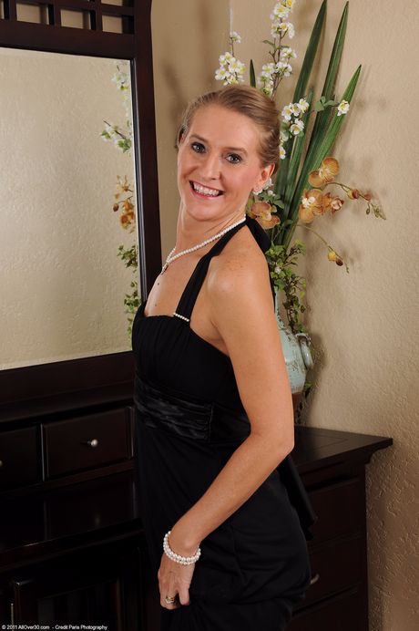 Amateur MILF Sara J undresses and shows her pierced pussy up close