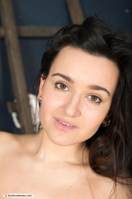 Brunette teen Sanita takes it all off on a bed during solo action