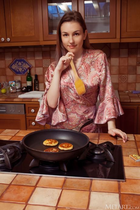 Stunning teen Isabele removes her robe and panties to pose nude in the kitchen