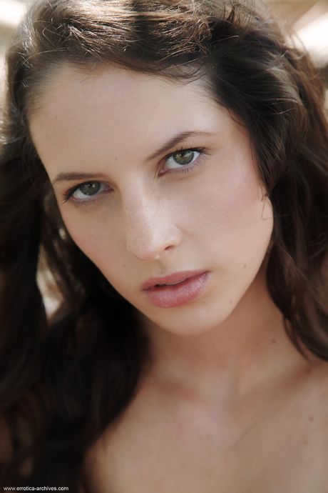 Naked teen Kamlyn strikes great solo poses on a tree in the sand