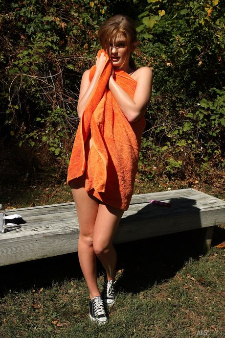 Leggy redhead Faye Reagan bares her body on a blanket in a backyard