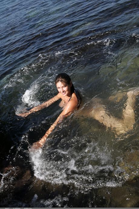 ブルネットのティーン、ヴァレラが巨乳を露わにし、水中でヌードポーズをとる。

