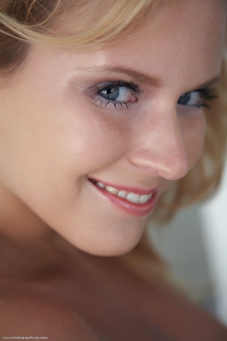 Blonde teen Raylene -modeller nøgne i høje hæle på en terrassestol
